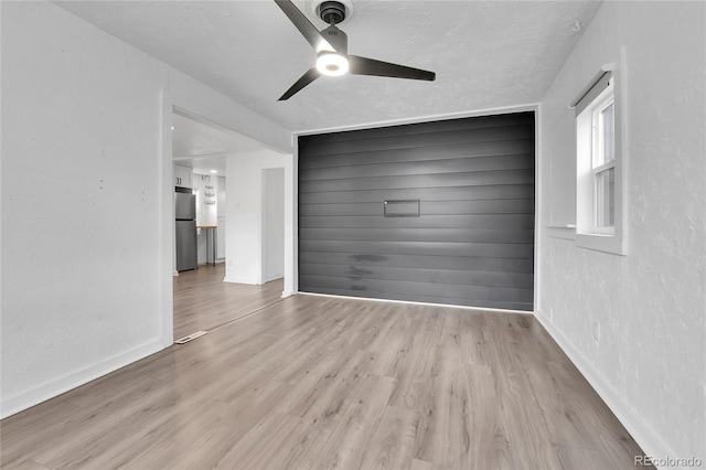 interior space featuring baseboards, ceiling fan, and wood finished floors