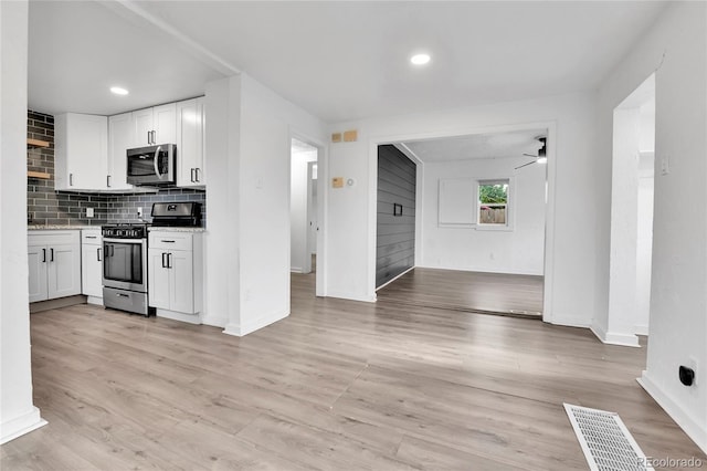 kitchen featuring ceiling fan, visible vents, appliances with stainless steel finishes, baseboards, and white cabinetry