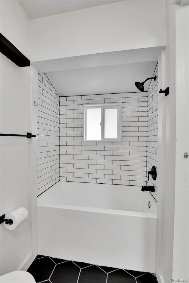 bathroom featuring tile patterned flooring, toilet, and shower / washtub combination