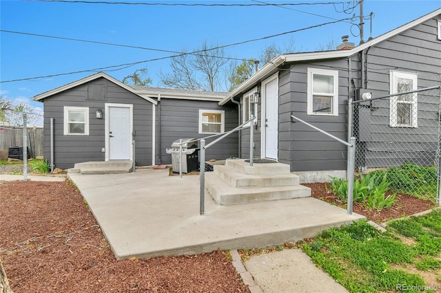 view of front of home with a patio area, fence, and a chimney