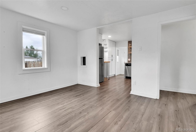 unfurnished living room featuring baseboards, recessed lighting, and wood finished floors