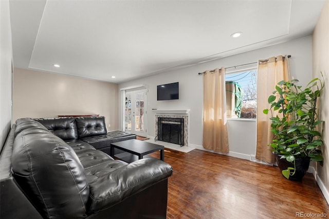 living room with dark hardwood / wood-style floors and a tiled fireplace