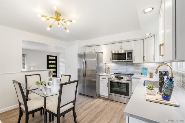 1772 S Pierce St, Lakewood, CO 80232 - kitchen with a sink, light countertops, a chandelier, stainless steel appliances, and decorative backsplash