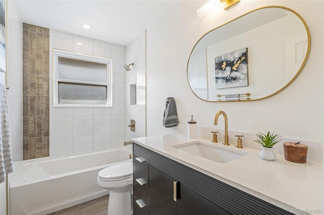 1772 S Pierce St, Lakewood, CO 80232 - bathroom with vanity, washtub / shower combination, wood finished floors, and toilet