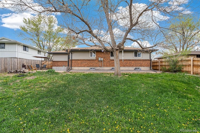 1772 S Pierce St, Lakewood, CO 80232 - rear view of property with a fenced backyard, a yard, and brick siding