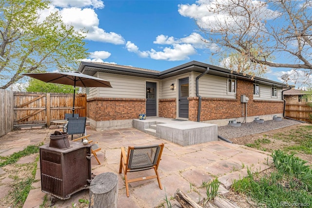 1772 S Pierce St, Lakewood, CO 80232 - back of property with a gate, brick siding, a fenced backyard, a patio, and a fire pit