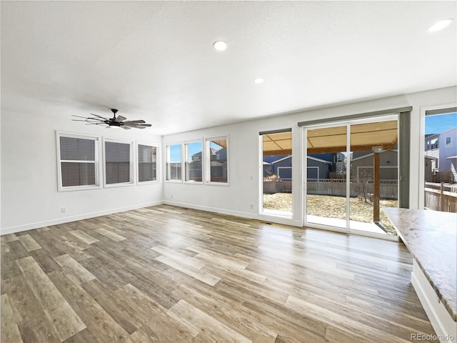 unfurnished sunroom featuring ceiling fan