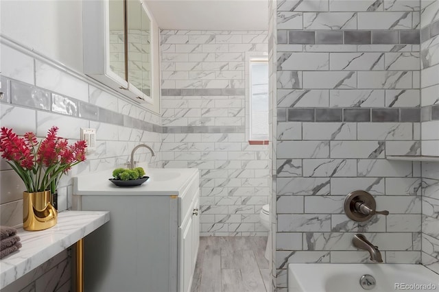 8110 Ivy St, Dupont, CO 80024 - full bathroom with tile walls, vanity, shower / tub combination, and toilet
