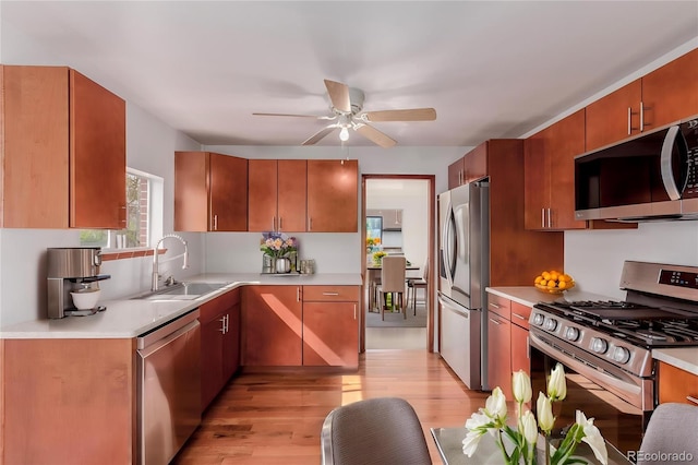 8110 Ivy St, Dupont, CO 80024 - kitchen with stainless steel appliances, a sink, light wood finished floors, and light countertops