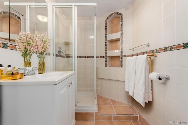 8110 Ivy St, Dupont, CO 80024 - bathroom with tile walls, a shower stall, vanity, and tile patterned floors