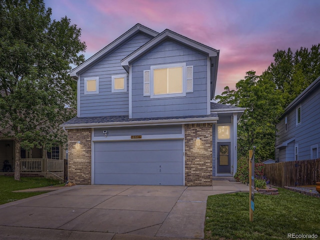 6447 St Vrain Ranch Blvd, Longmont, CO 80504 - view of front of home with brick siding, driveway, an attached garage, and a shingled roof