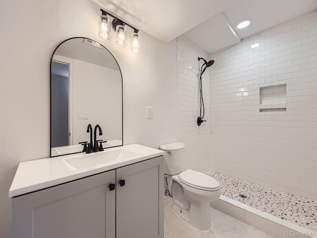 6447 St Vrain Ranch Blvd, Longmont, CO 80504 - bathroom with a tile shower, vanity, toilet, and tile patterned flooring