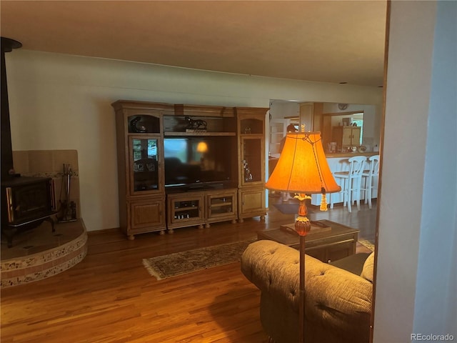 living room with wood-type flooring and a wood stove