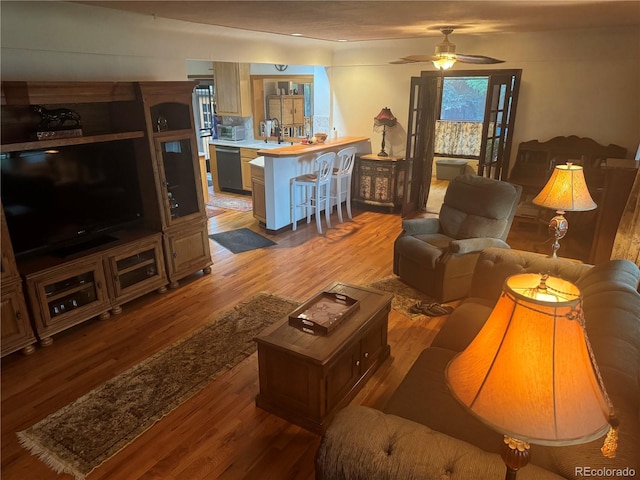 living room with wood-type flooring and ceiling fan