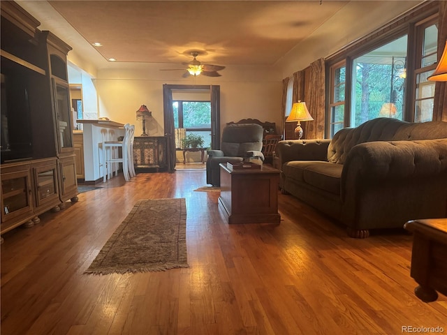 living room with dark wood-type flooring and ceiling fan