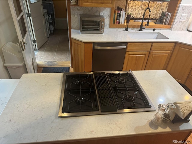 kitchen with sink, tile patterned floors, gas cooktop, backsplash, and stainless steel dishwasher