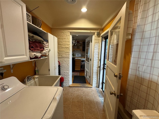 laundry area featuring cabinets, tile patterned floors, washer / dryer, and sink