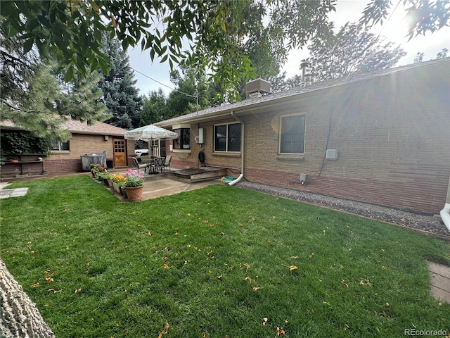 rear view of property featuring central AC unit, a lawn, and a patio