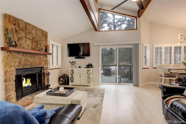 living area with a fireplace, wood finished floors, beam ceiling, and a healthy amount of sunlight