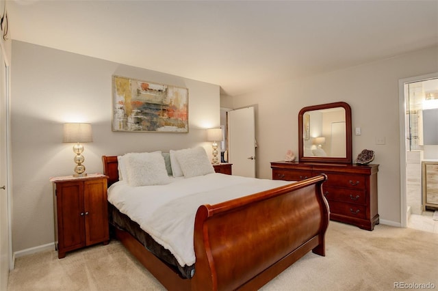 bedroom featuring baseboards, ensuite bath, and light colored carpet