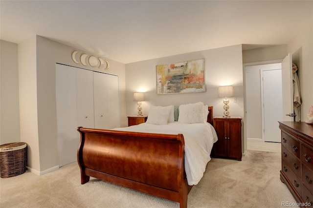 bedroom featuring baseboards, a closet, and light colored carpet