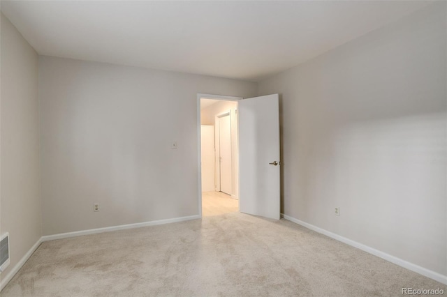 unfurnished room featuring visible vents, baseboards, and light colored carpet