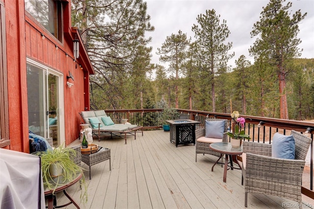 wooden terrace featuring a view of trees