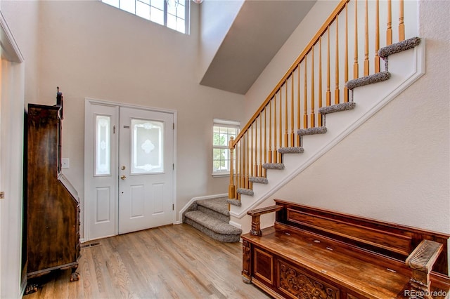895 Antelope Dr W, Bennett, CO 80102 - entryway featuring a towering ceiling, stairs, healthy amount of natural light, light wood-type flooring, and baseboards
