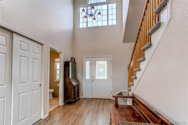 895 Antelope Dr W, Bennett, CO 80102 - foyer with a chandelier, wood finished floors, stairs, and a towering ceiling