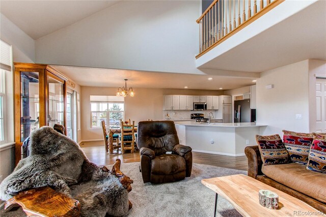 895 Antelope Dr W, Bennett, CO 80102 - living room with a chandelier, wood finished floors, high vaulted ceiling, baseboards, and recessed lighting