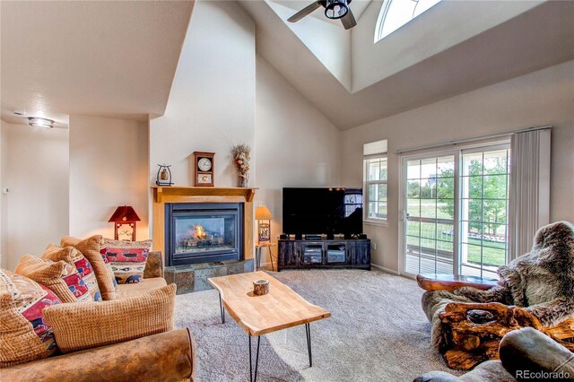 895 Antelope Dr W, Bennett, CO 80102 - carpeted living area with high vaulted ceiling, a ceiling fan, a tile fireplace, and baseboards