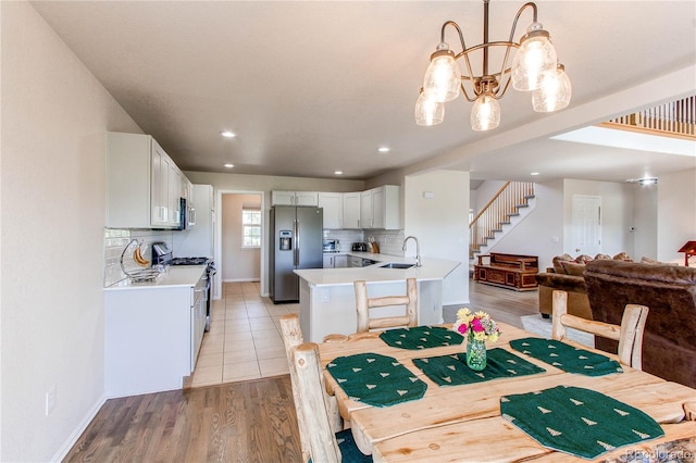 895 Antelope Dr W, Bennett, CO 80102 - dining space featuring a chandelier, baseboards, light wood-style floors, recessed lighting, and stairway