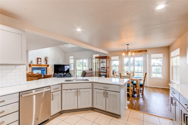 895 Antelope Dr W, Bennett, CO 80102 - kitchen with dishwasher, a sink, a peninsula, light countertops, and a chandelier