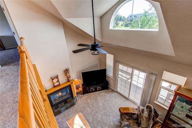 895 Antelope Dr W, Bennett, CO 80102 - carpeted living room featuring high vaulted ceiling, a glass covered fireplace, and ceiling fan