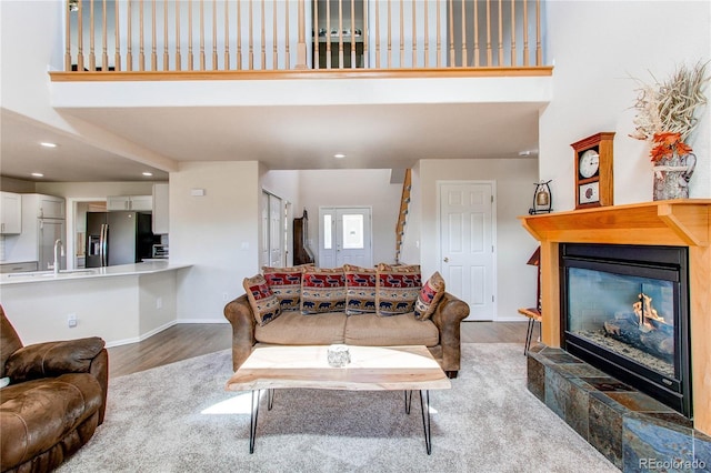 895 Antelope Dr W, Bennett, CO 80102 - living area featuring a high ceiling, wood finished floors, a glass covered fireplace, recessed lighting, and baseboards