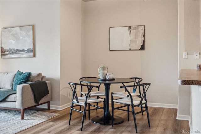 dining space with wood finished floors and baseboards