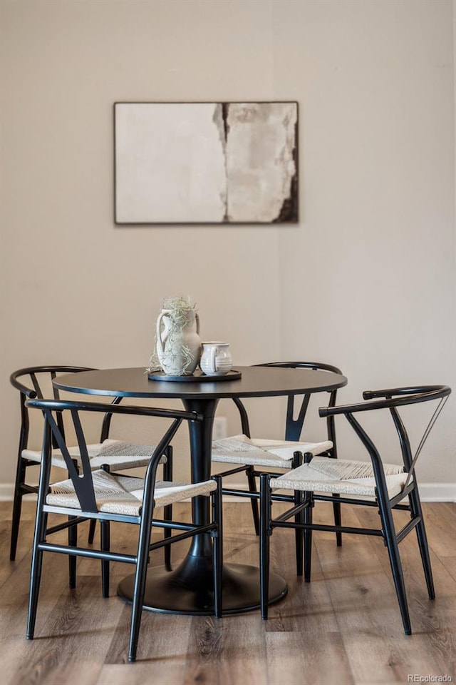 dining area featuring baseboards and wood finished floors