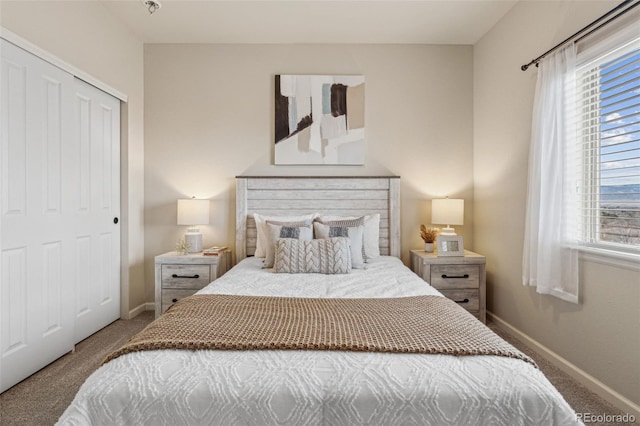 carpeted bedroom featuring multiple windows, a closet, and baseboards