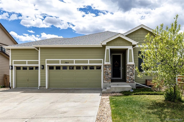 craftsman inspired home featuring concrete driveway, an attached garage, and a front yard