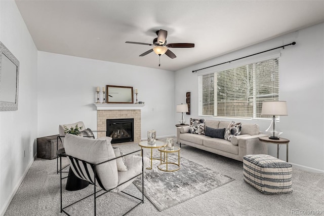 carpeted living room with baseboards, ceiling fan, and a tiled fireplace