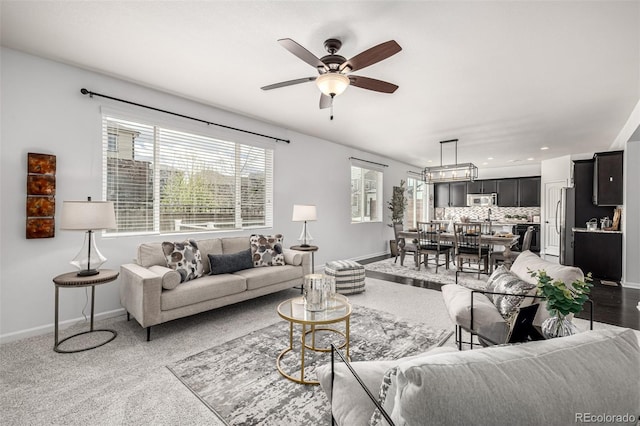 living area featuring baseboards and ceiling fan