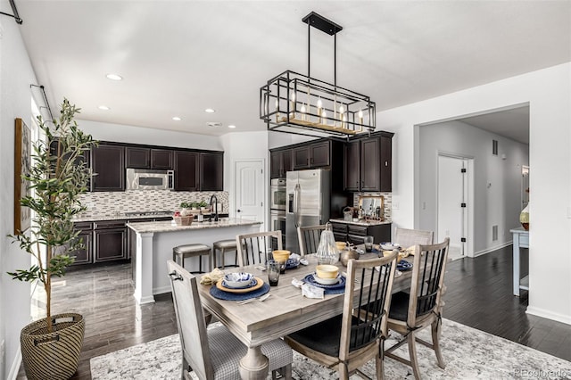 dining room featuring dark wood finished floors, recessed lighting, a chandelier, and baseboards