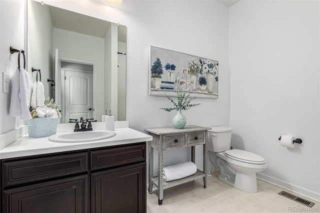 bathroom featuring toilet, vanity, and baseboards