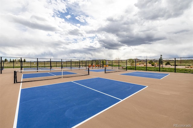 view of tennis court featuring community basketball court and fence