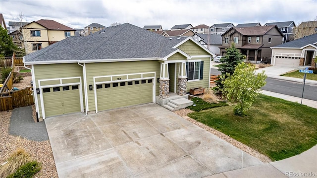 craftsman-style house featuring a residential view, a shingled roof, concrete driveway, and an attached garage