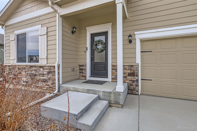 entrance to property with a garage and stone siding