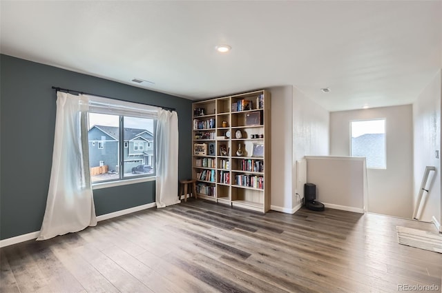 unfurnished room featuring wood finished floors, visible vents, and baseboards