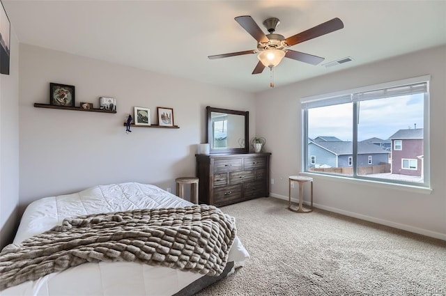 carpeted bedroom with visible vents, ceiling fan, and baseboards