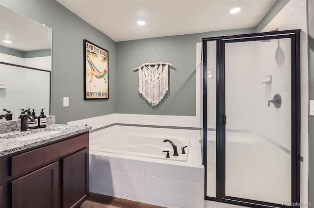 bathroom with vanity, a shower stall, a garden tub, and recessed lighting