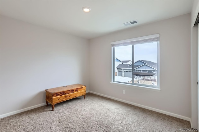 sitting room featuring visible vents, light carpet, and baseboards